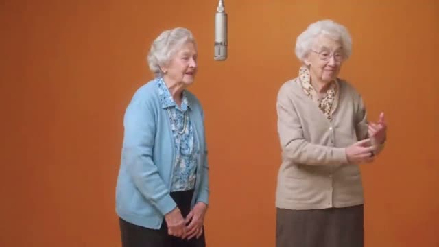 Due nonne che si alternano le strofe sotto il microfono sospeso.